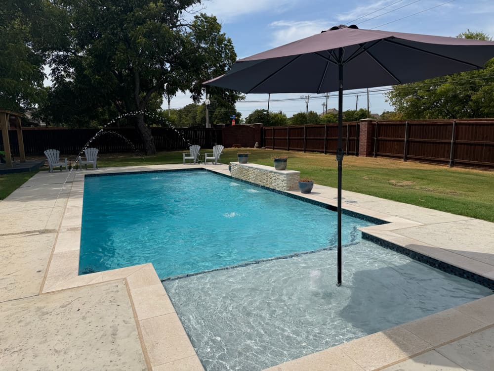 Custom pool with stone waterfall and outdoor lounge — LiquidLux, North Texas