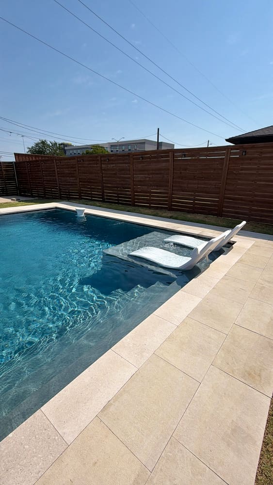 In-pool tanning ledge with floating loungers — LiquidLux Custom Pools